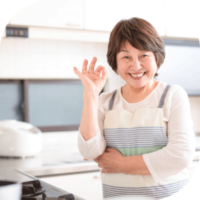 整ったキッチンでオーケーサインをするばあばの写真