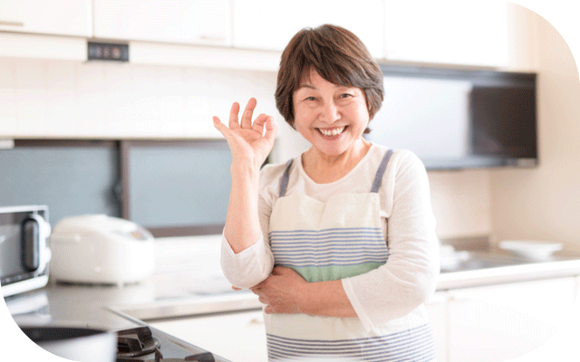 整ったキッチンでオーケーサインをするばあばの写真