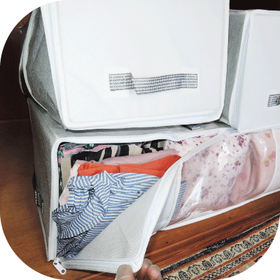 押入れに積み重なった布製の収納バッグを動かすことなく、ジッパーを開けるだけで中から衣類を取り出している様子